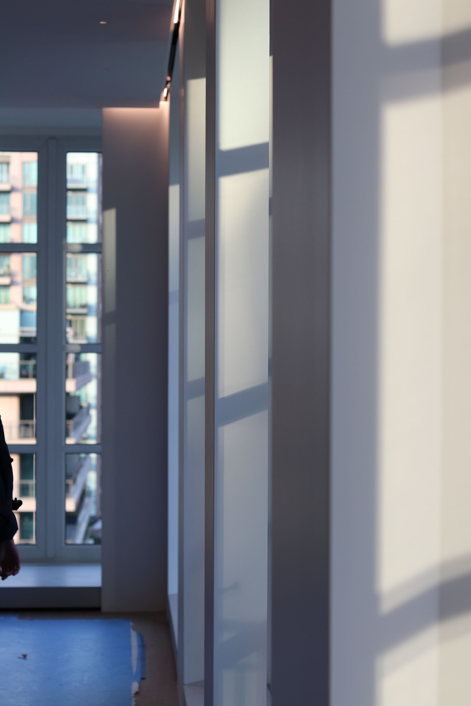 a shadow of a person is cast on a wall in a hallway