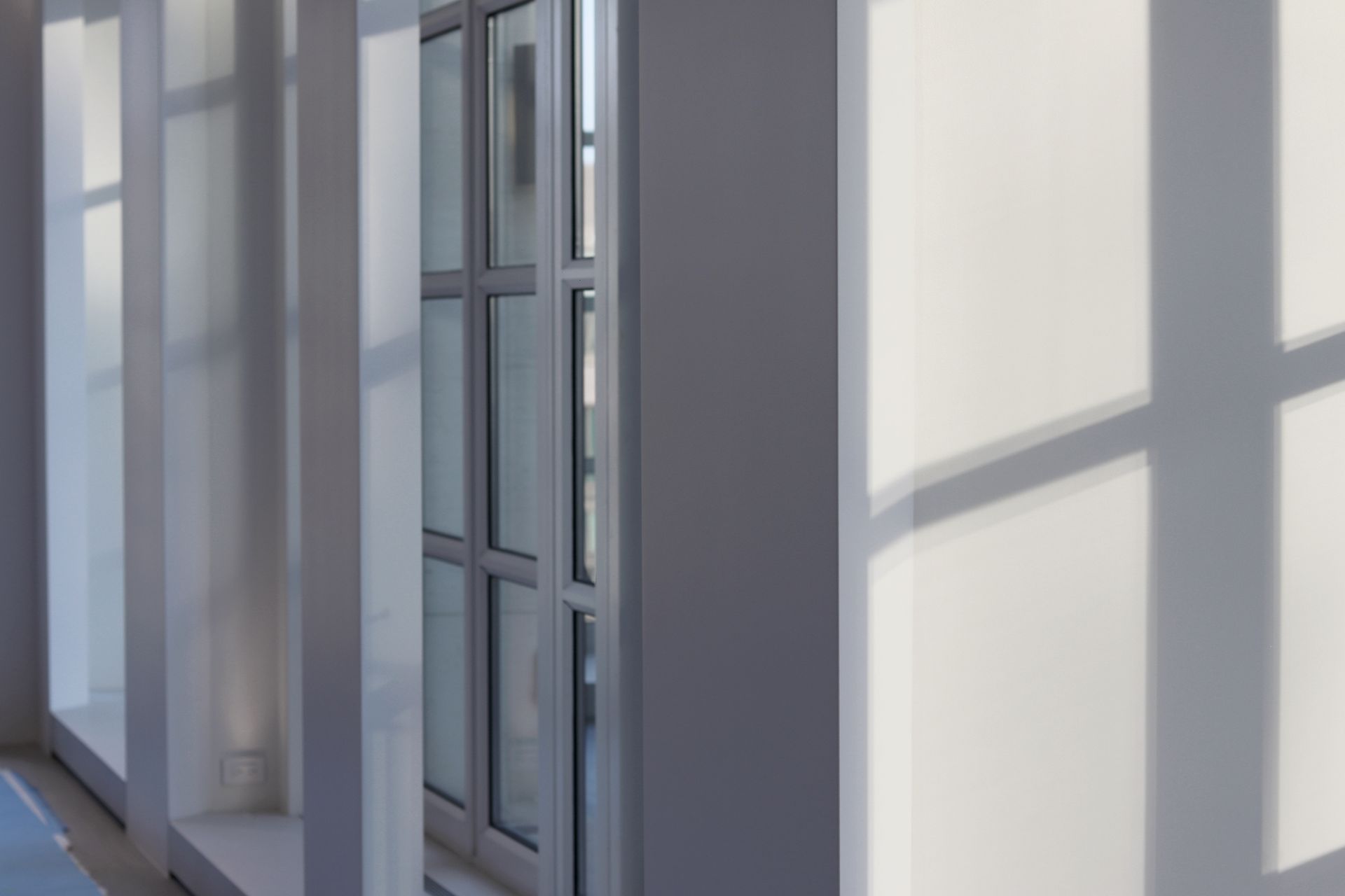 a hallway with a window and a shadow on the wall .