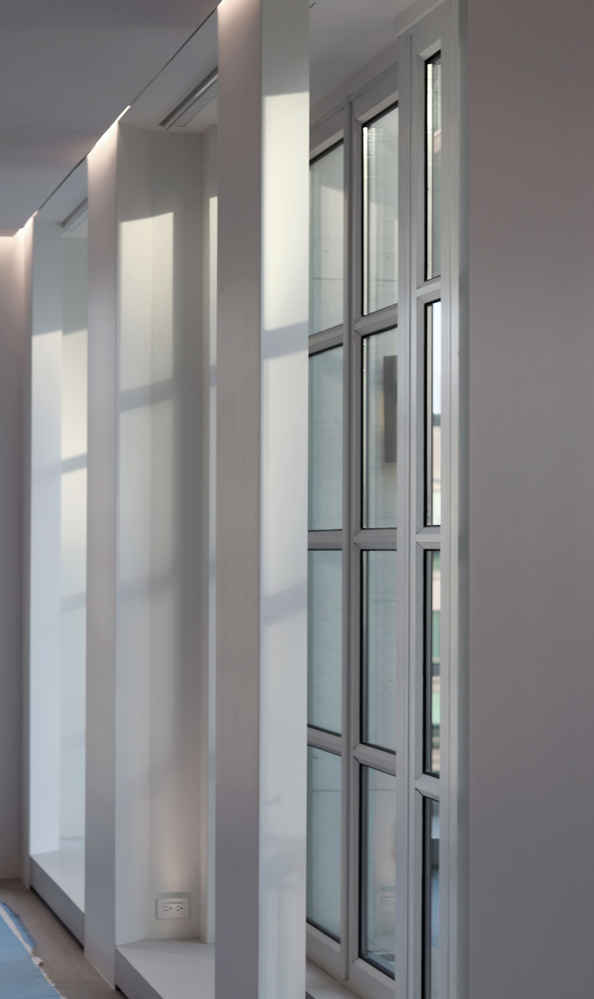 a hallway with a lot of windows and a door .