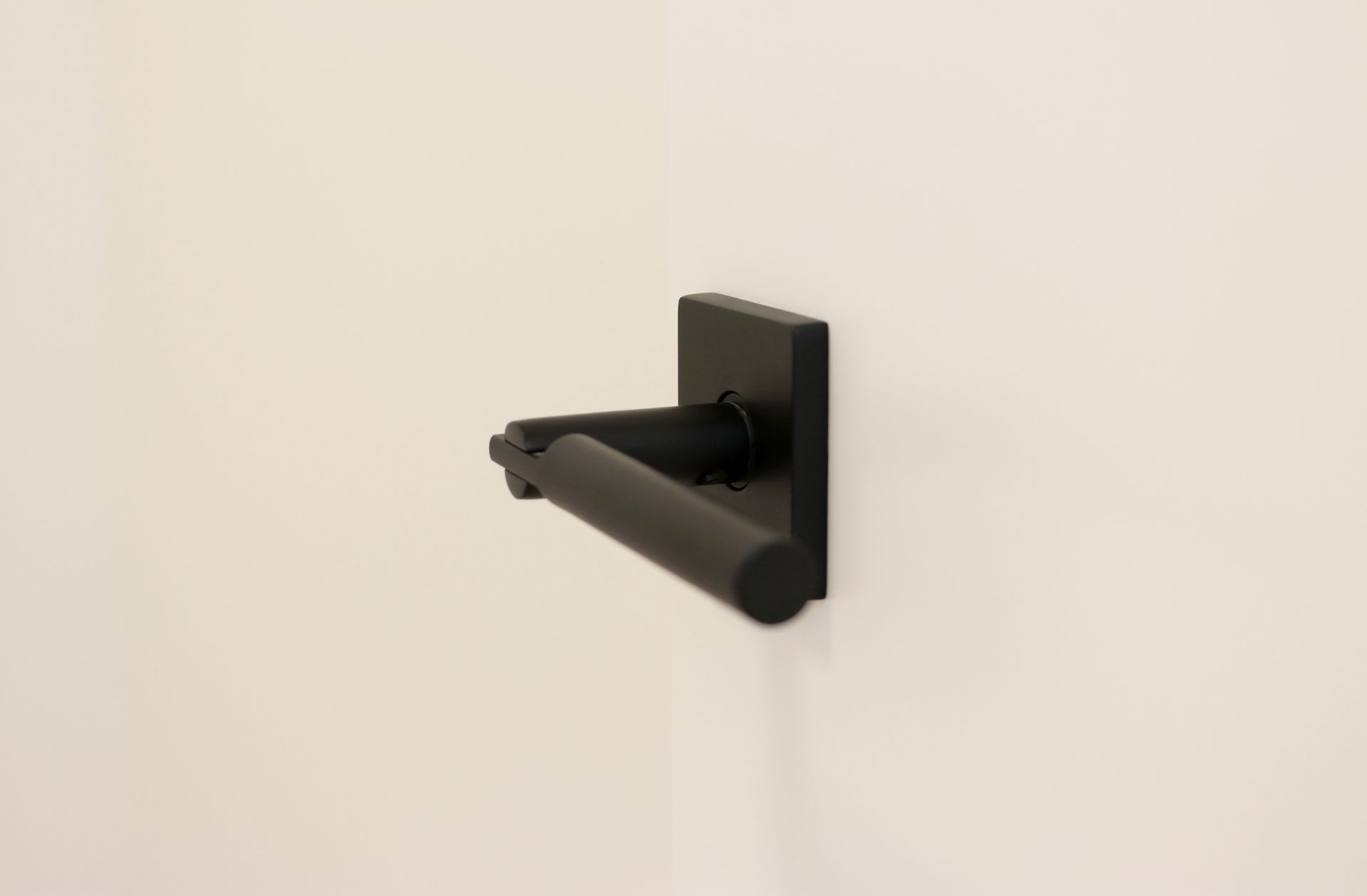 a black door handle is hanging on a white wall .