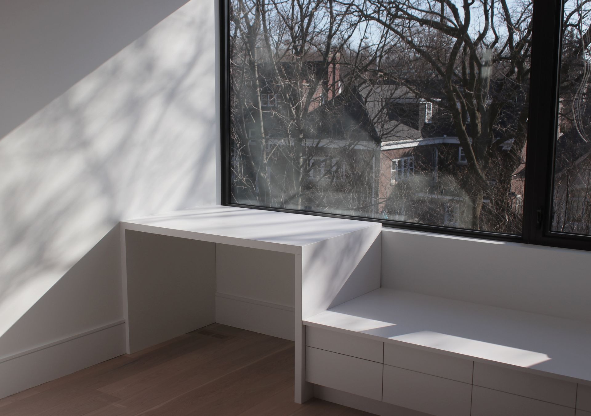 an empty room with a window seat and a desk