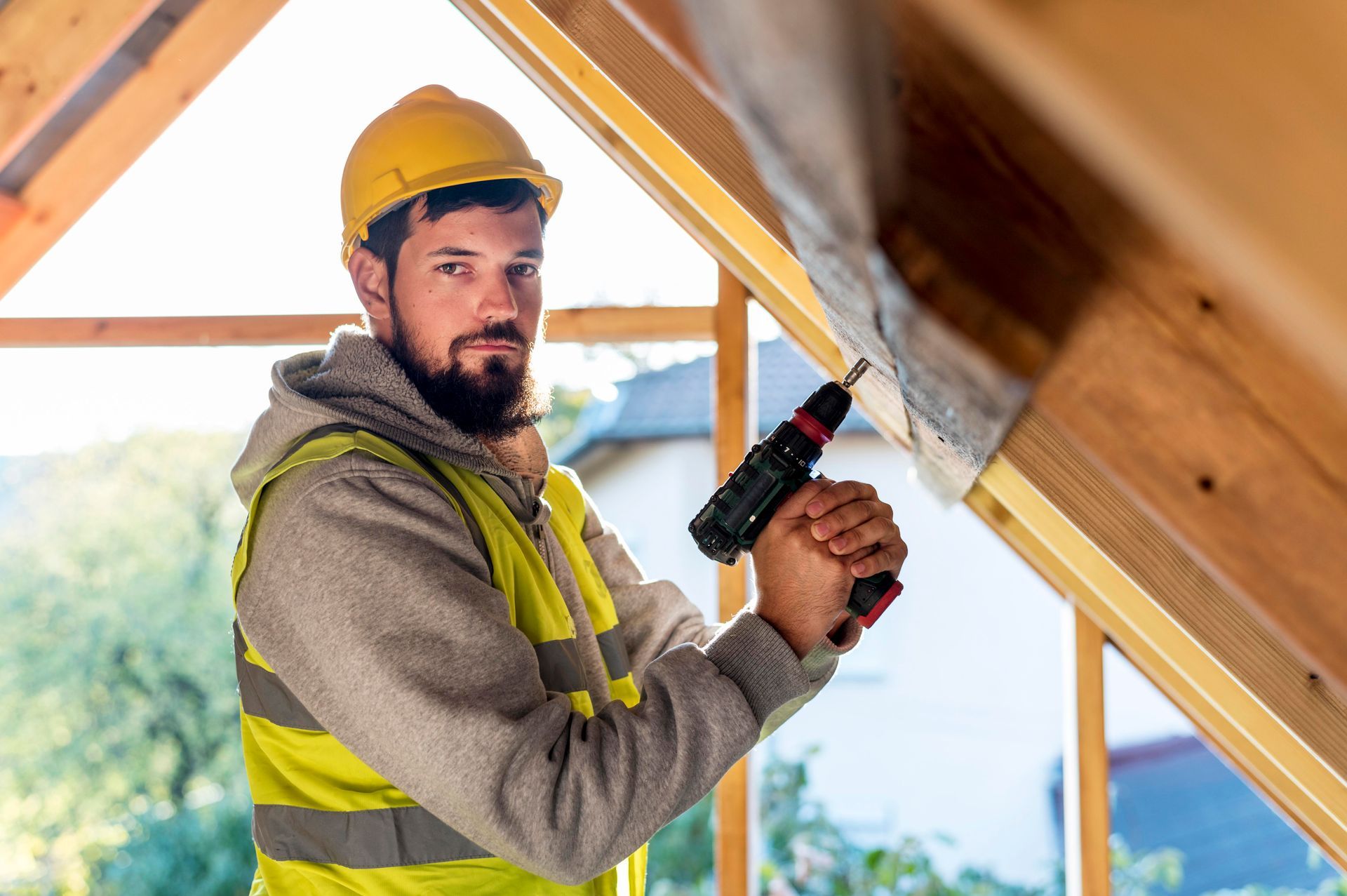 a man is using a drill on a wooden roof .