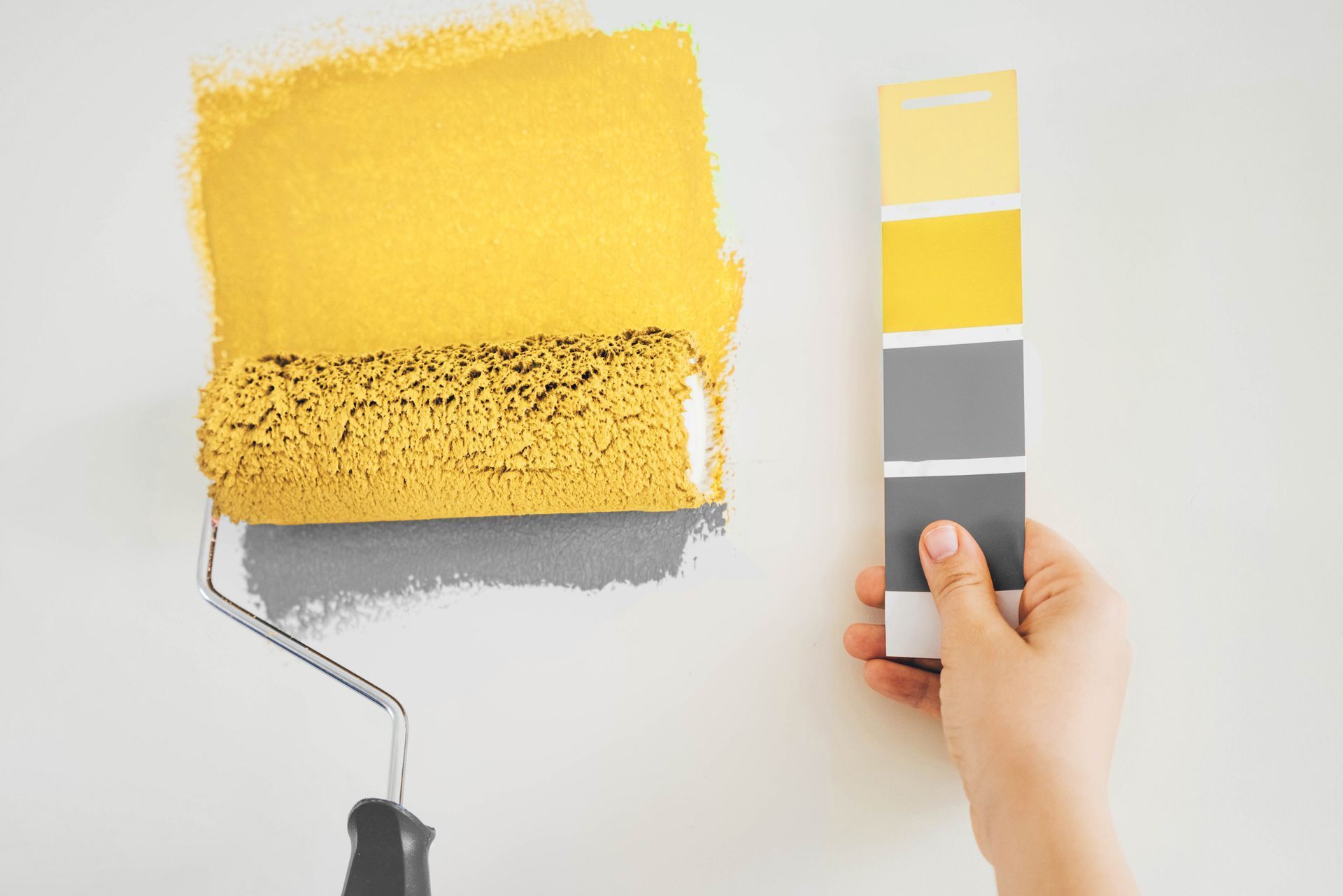 a person is holding a paint swatch next to a paint roller .