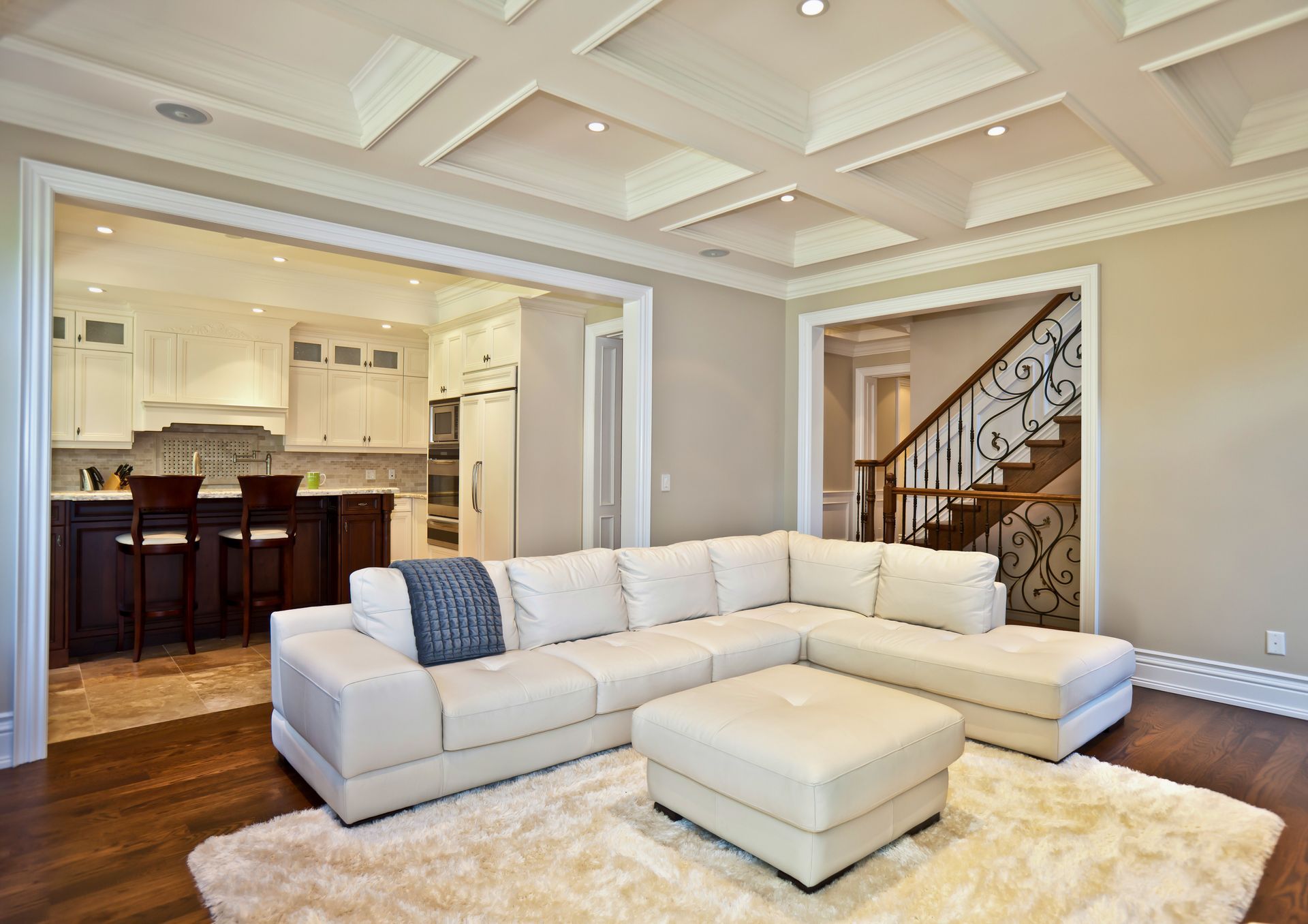 a living room with a large sectional couch and ottoman