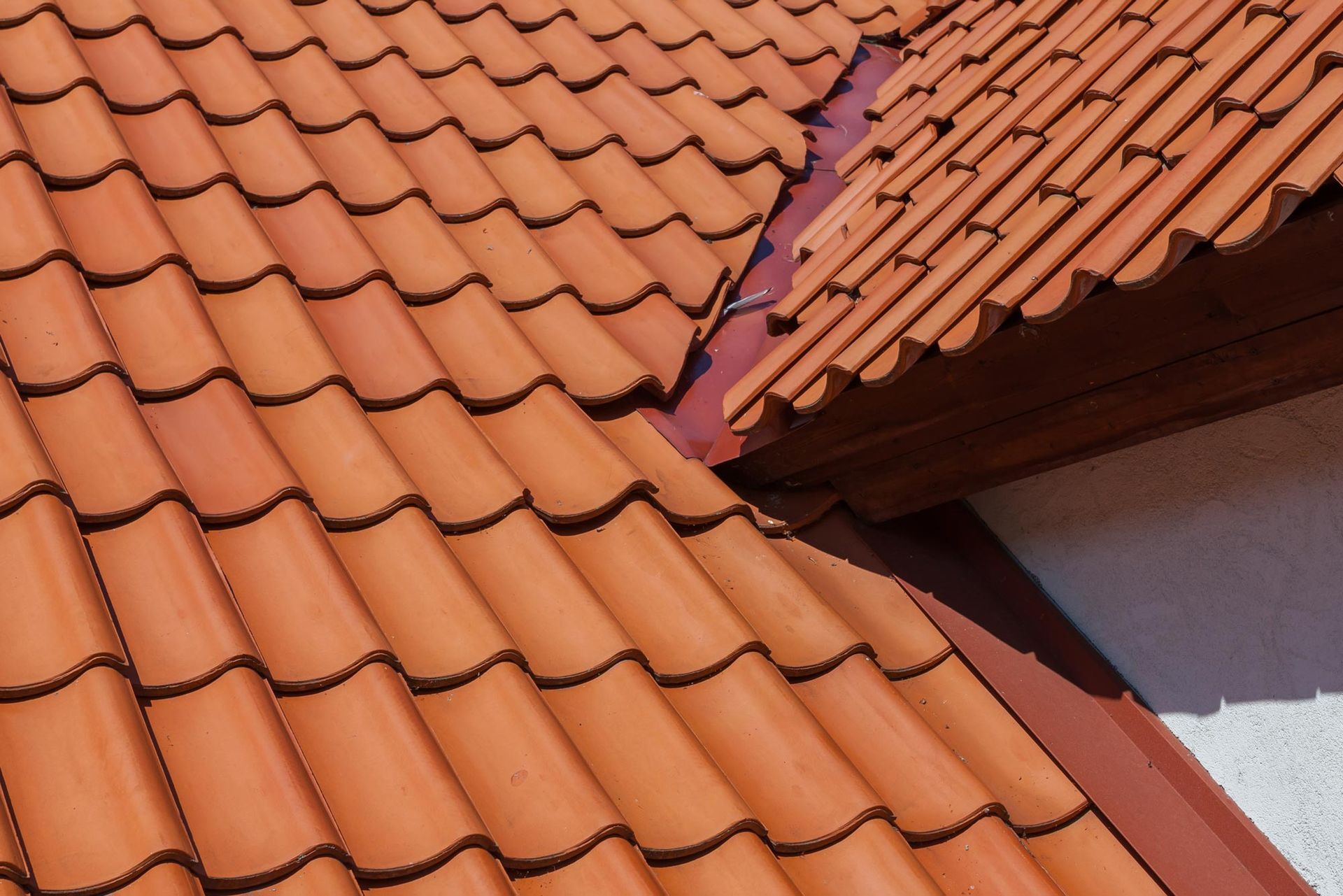 A close up of a roof with red tiles