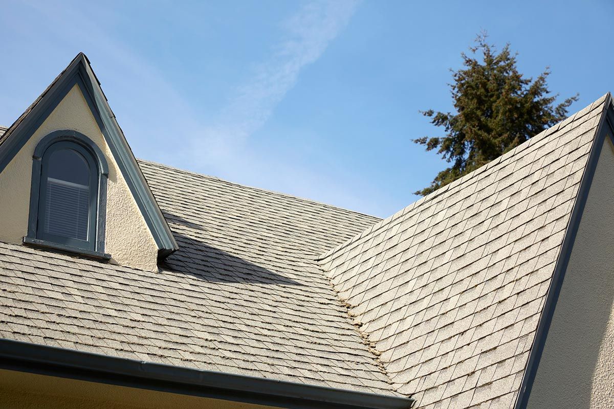 The roof of a house has a window on it The roof of a house has a window on it