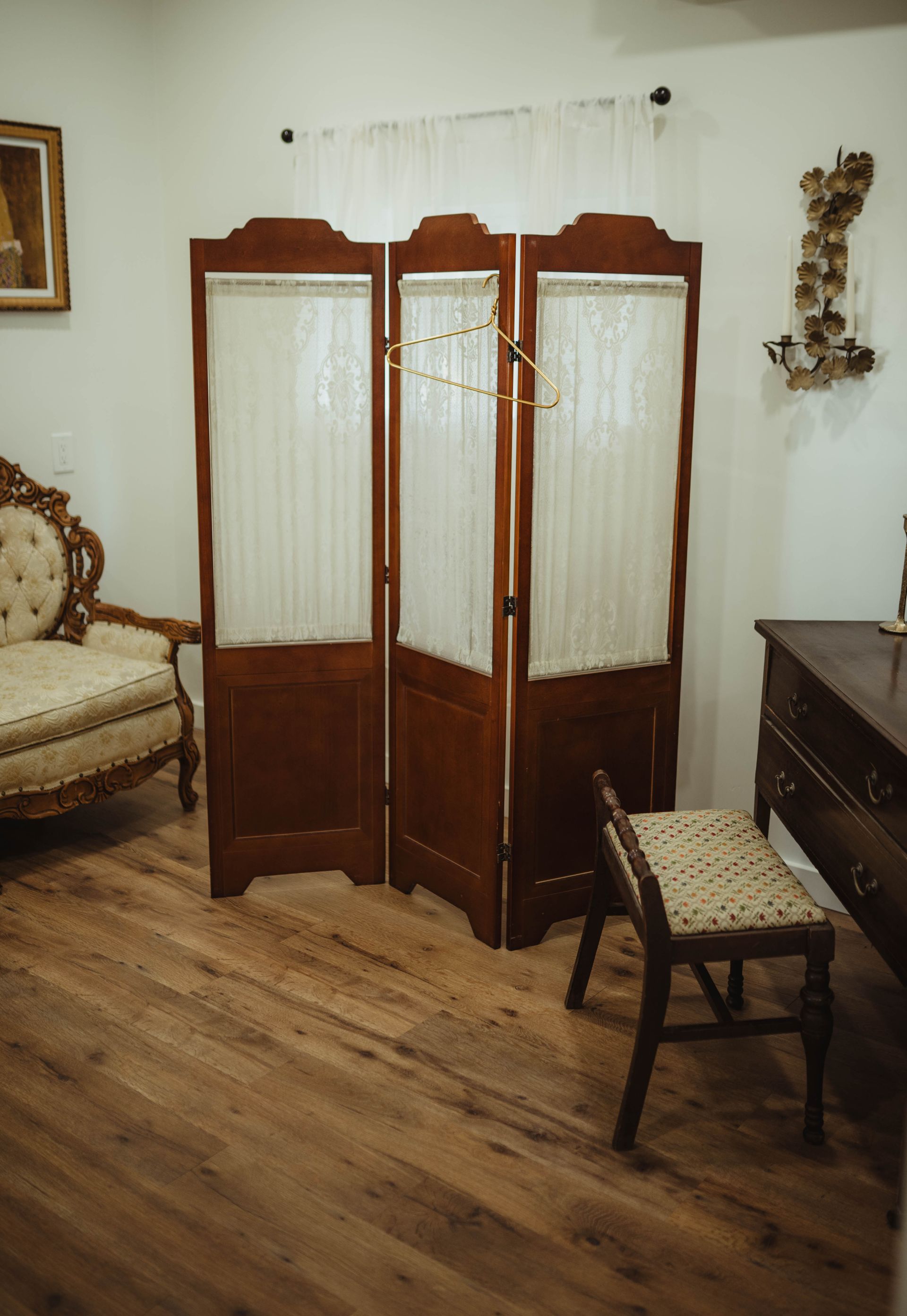 Wooden privacy screen in a room with antique furniture and a small stool.