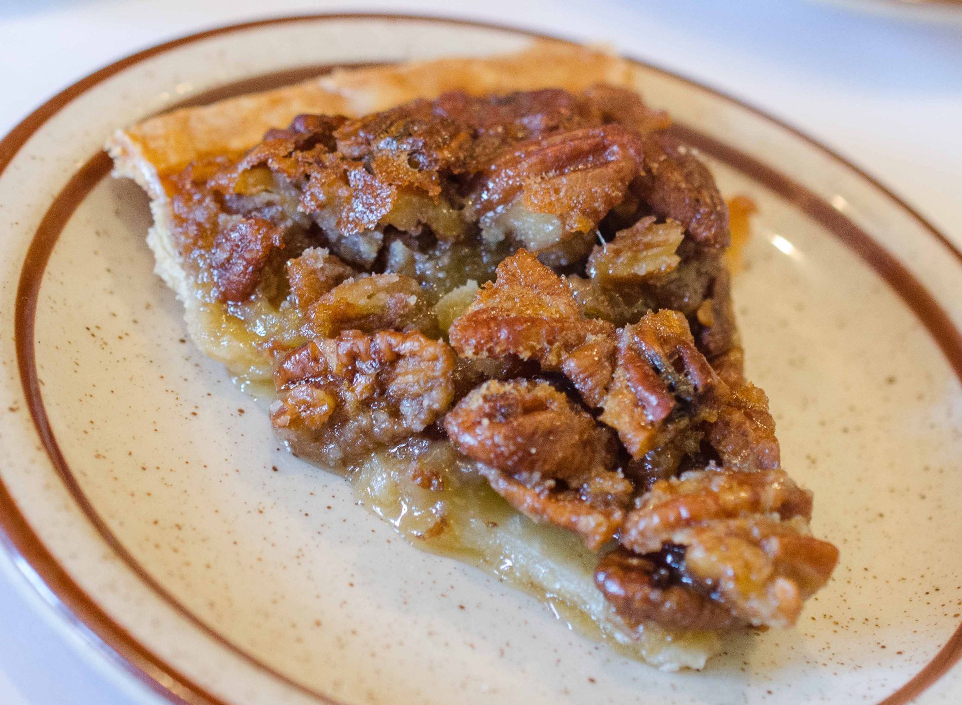 A slice of pecan pie is on a plate.