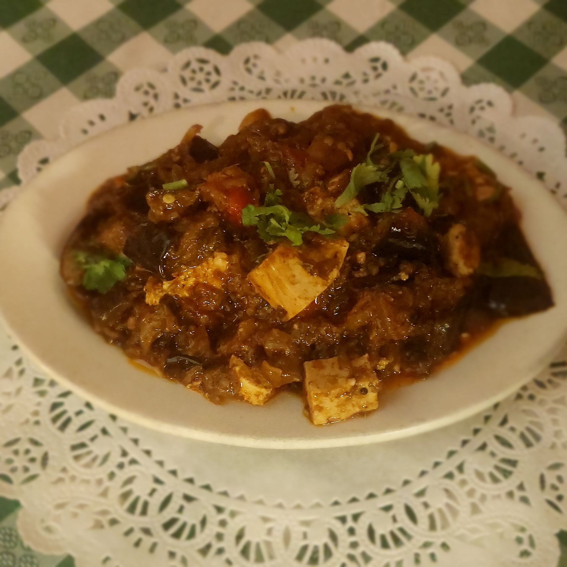 A plate of food on a table with a checkered table cloth