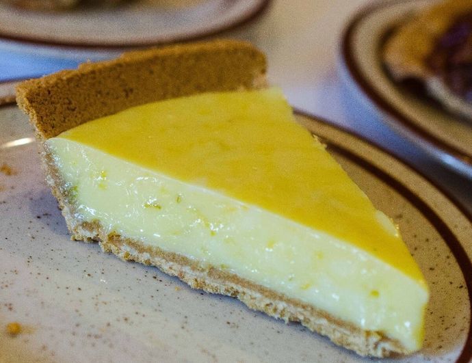 A slice of lemon pie is on a plate.