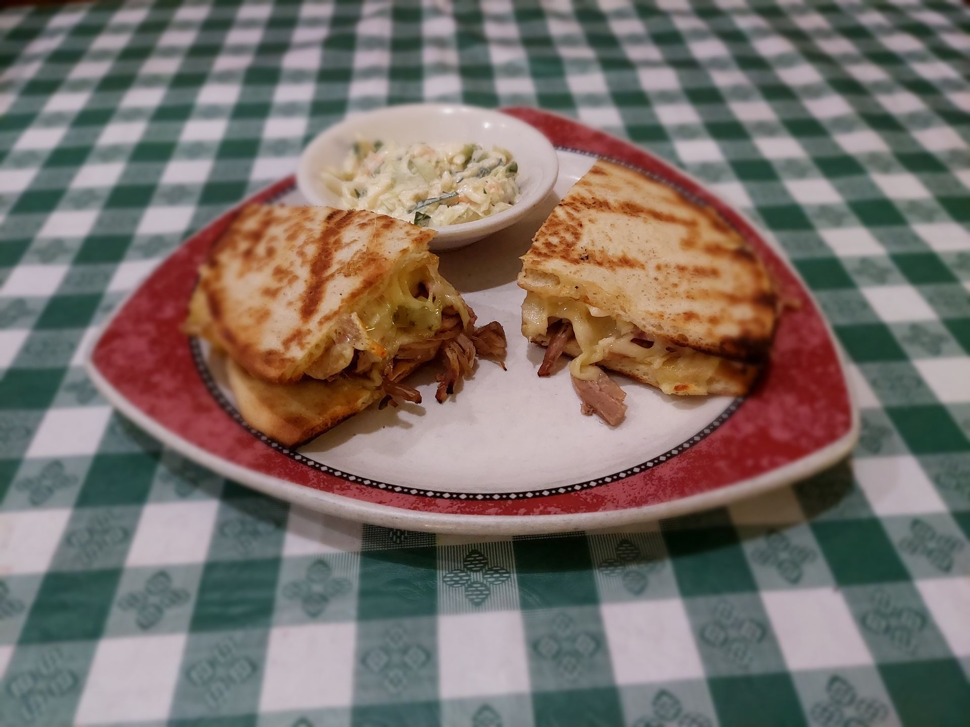 A sandwich on a plate with a side of coleslaw