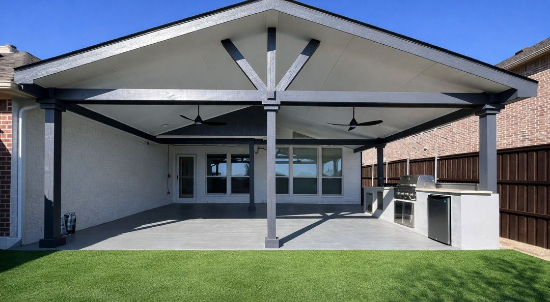 Backyard patio with patterned concrete and black pergola attached to a white house. Backyard patio with patterned concrete and black pergola attached to a white house.