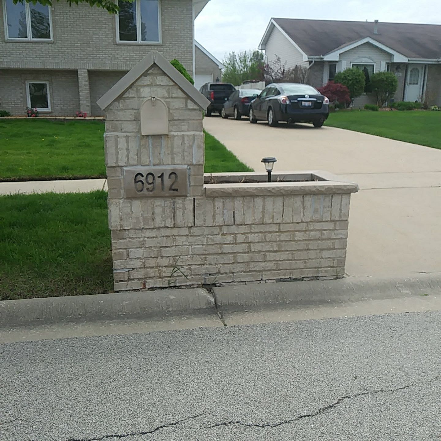 A brick wall with the address 6912 on it