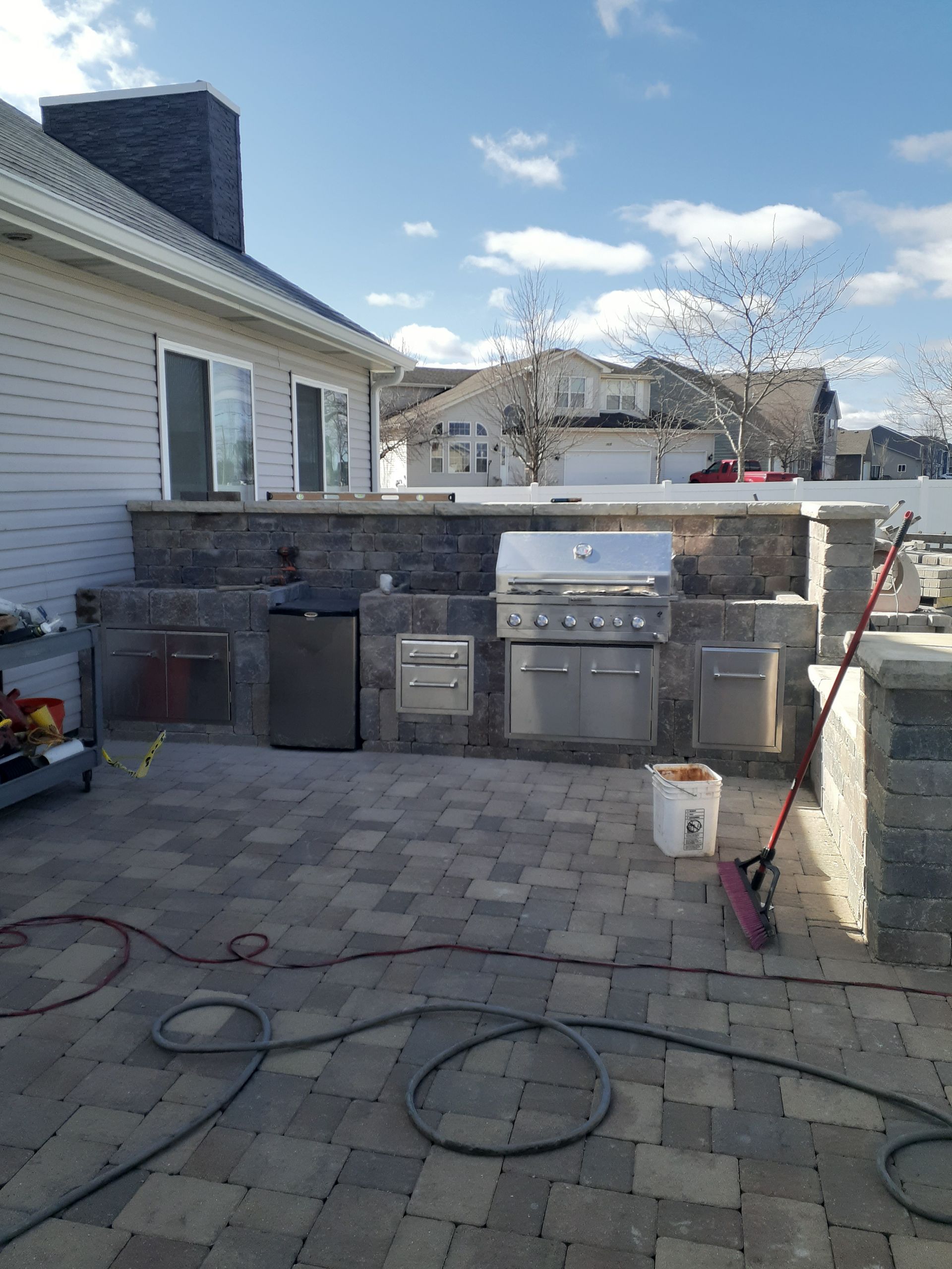 An outdoor kitchen is being built in the backyard of a house.