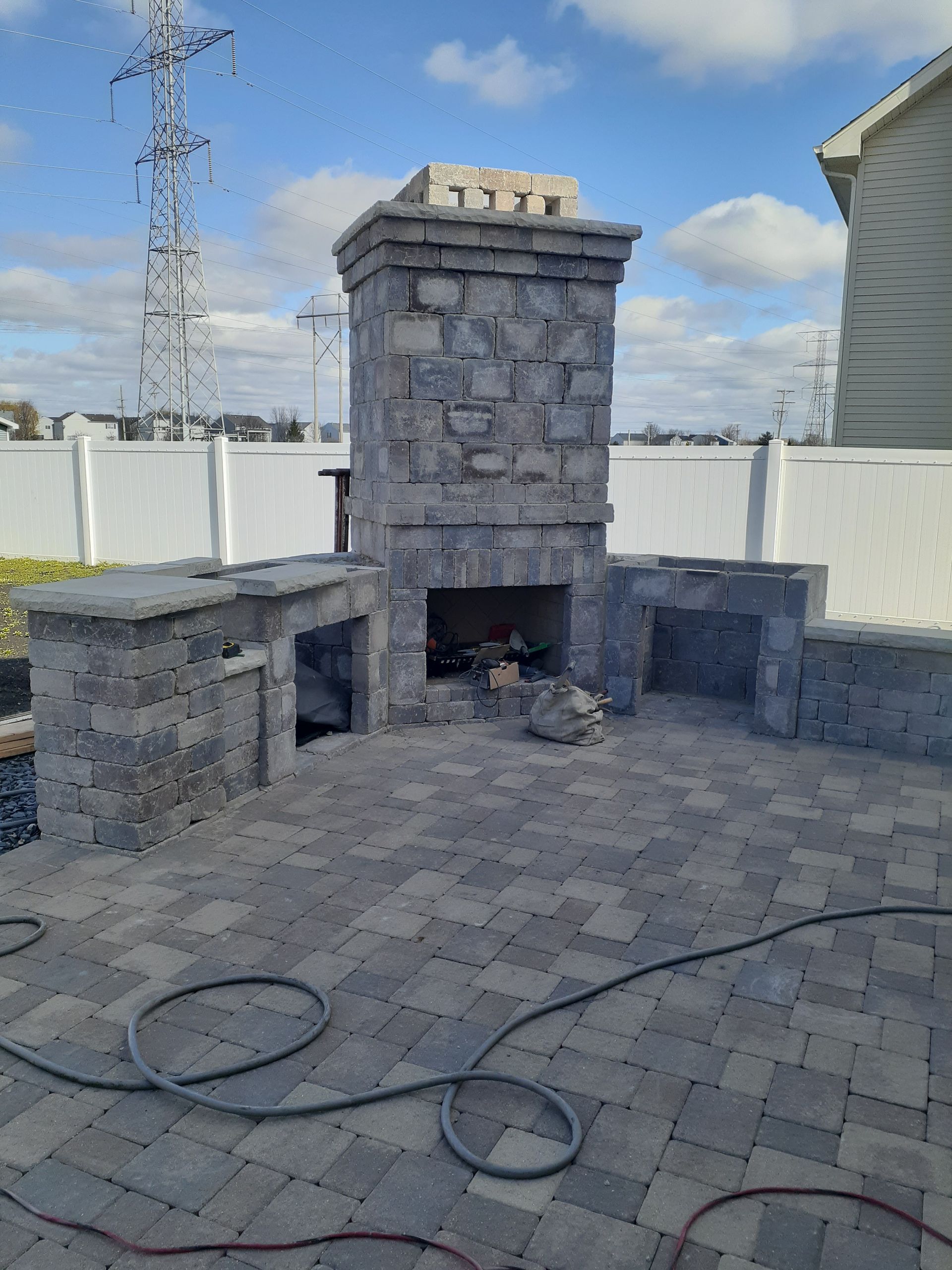 A brick fireplace is being built on a patio