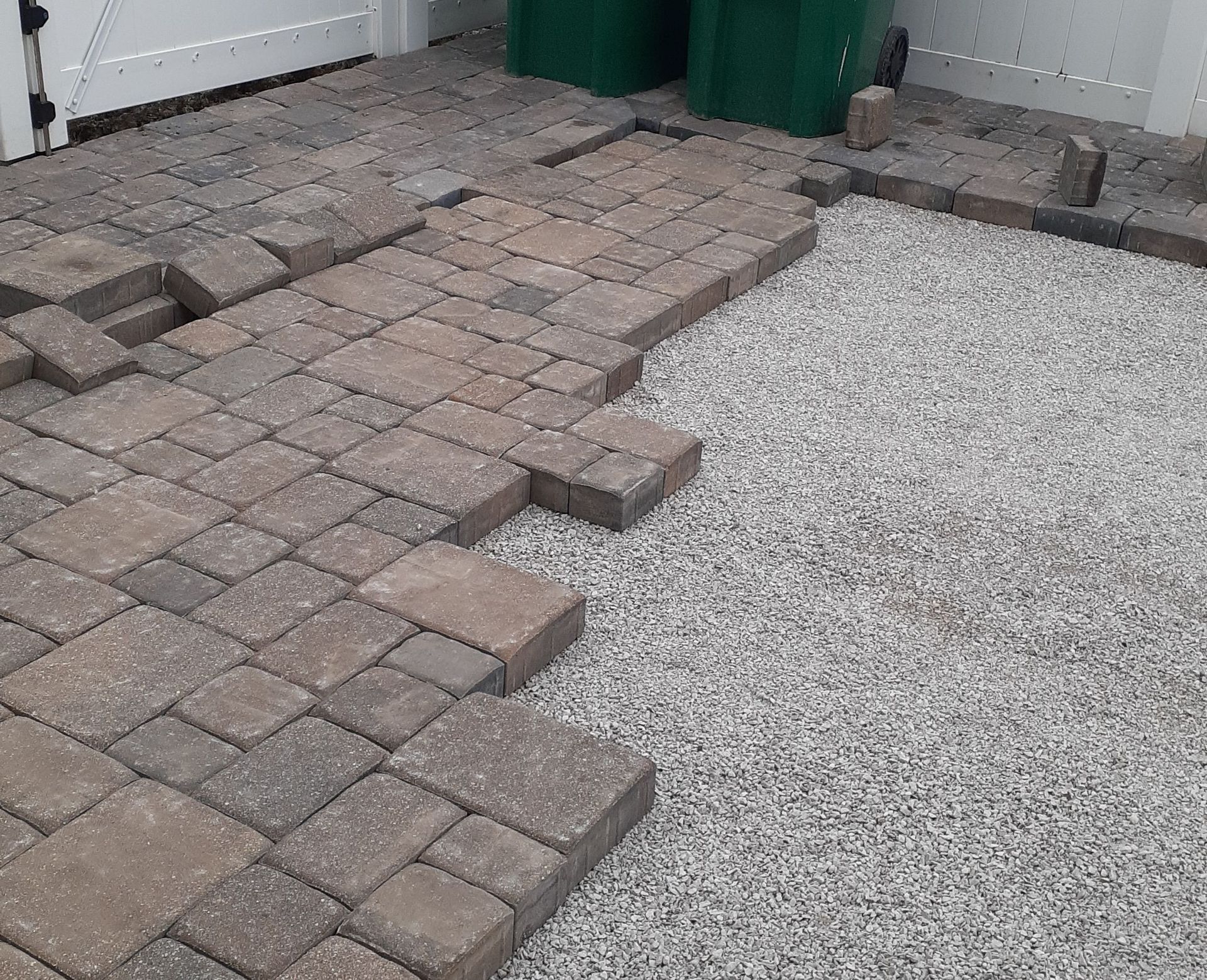 A brick walkway is being built in a driveway.