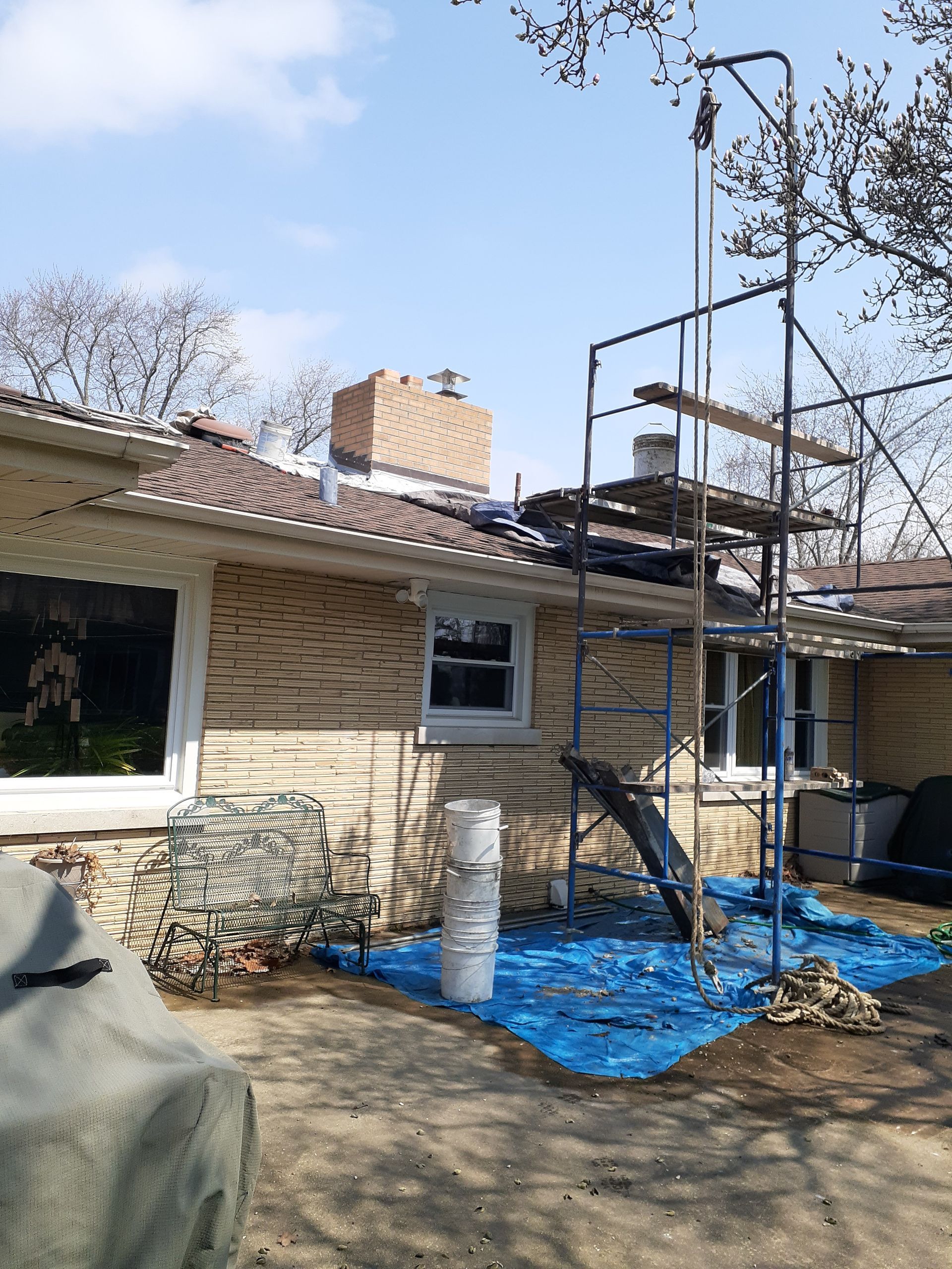 A house with a scaffolding in front of it is being painted.