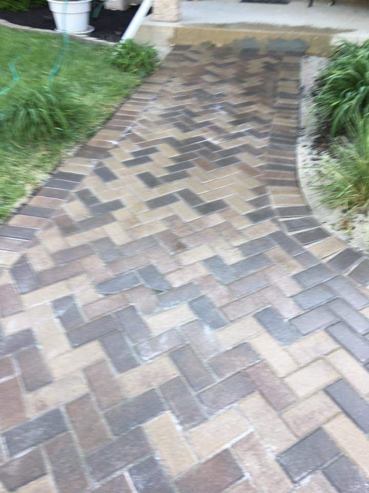 A walkway made of bricks in a herringbone pattern.