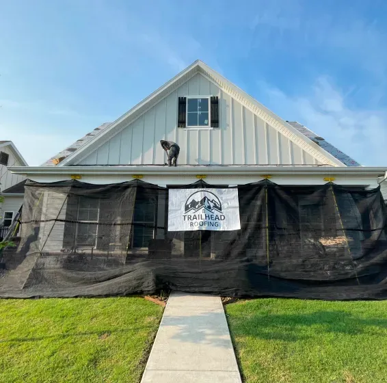 A white house with a black tarp on the front of it.