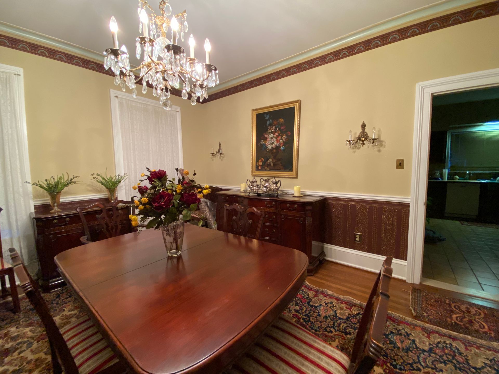 A dining room with a table and chairs and a chandelier.