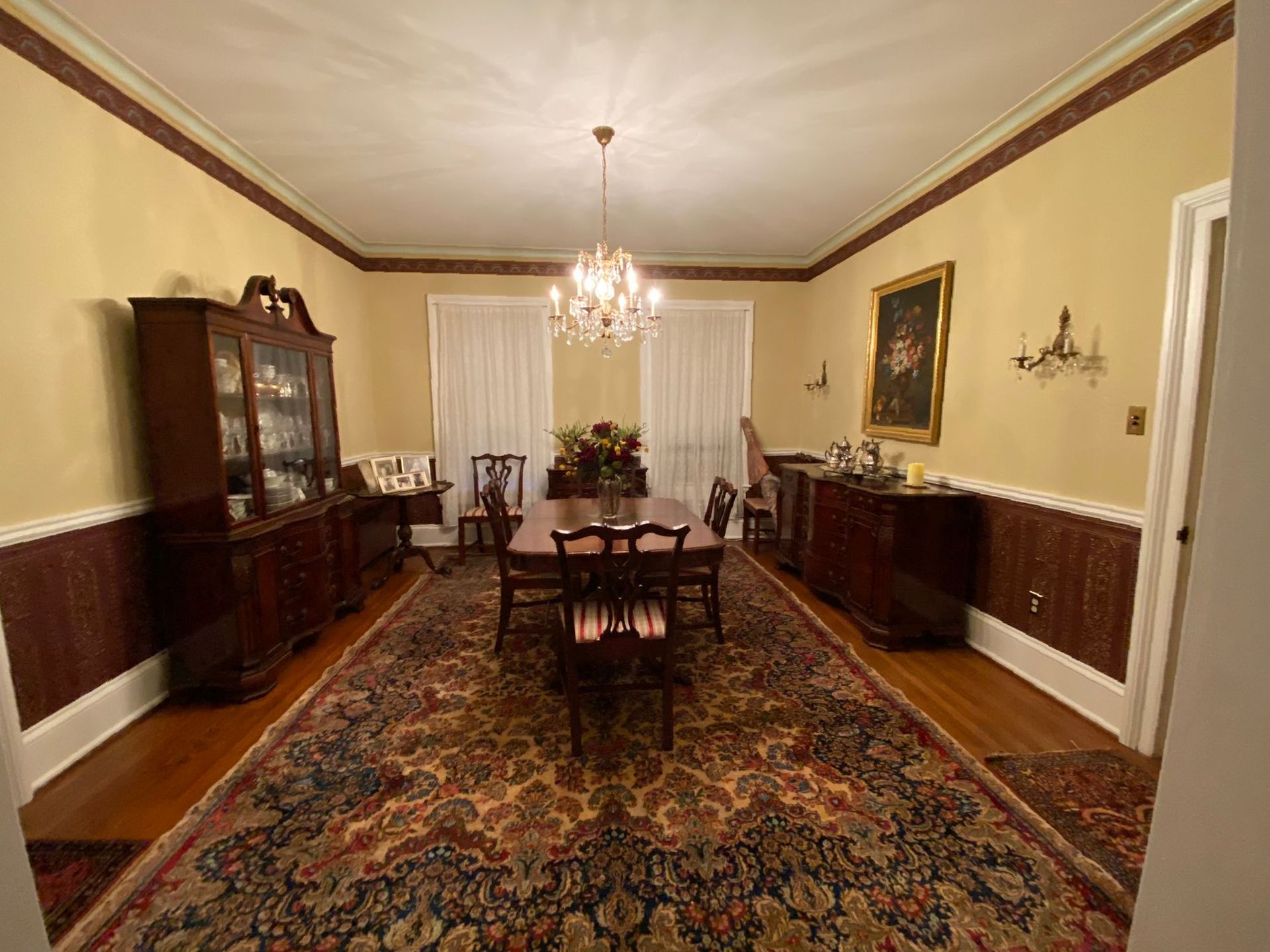 A large dining room with a table and chairs and a chandelier.