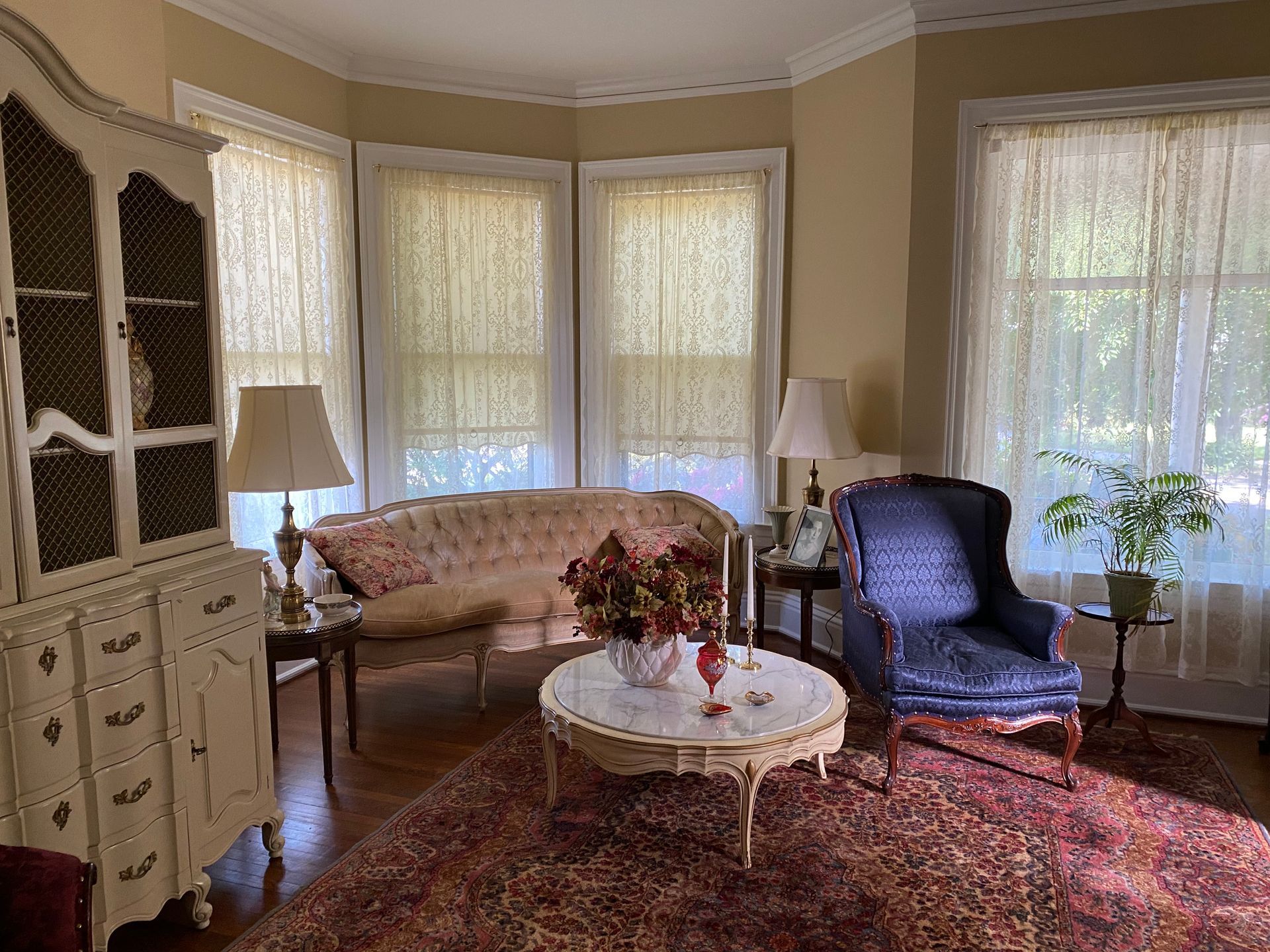 A living room with a couch , chair , coffee table and hutch.