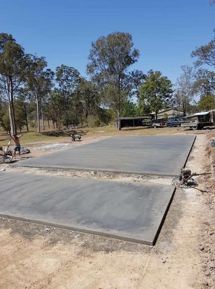 A Large Concrete Slab is Being Built in a Dirt Field With Trees in the Background — MidCoast Concreting in Old Bar, NSW