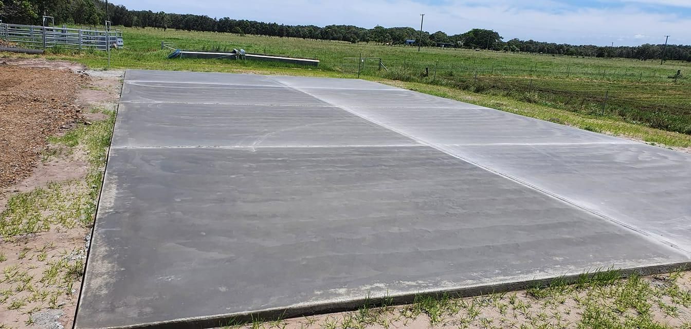 A Large Concrete Slab is Sitting in the Middle of a Grassy Field — MidCoast Concreting in Gloucester, NSW