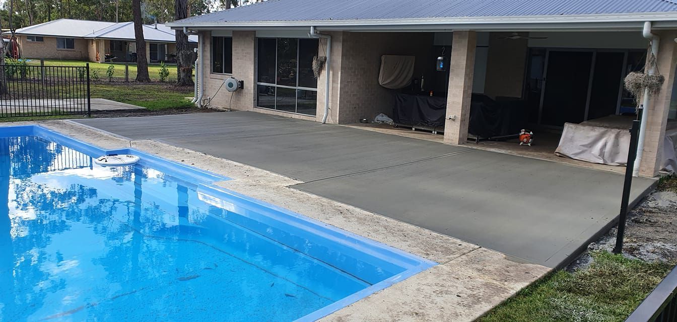 There is a large swimming pool in the backyard of a house. — MidCoast Concreting in Mount George, NSW