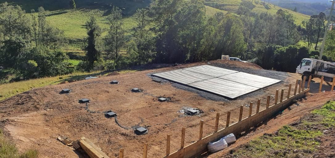 A Large Concrete Slab is Sitting on Top of a Dirt Field — MidCoast Concreting in Mount George, NSW