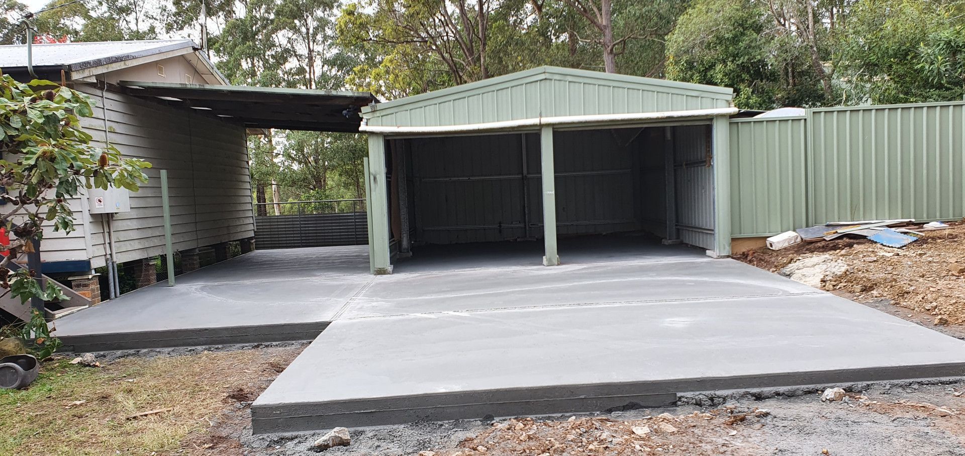 A concrete driveway is being built in front of a garage. — MidCoast Concreting in Mount George, NSW