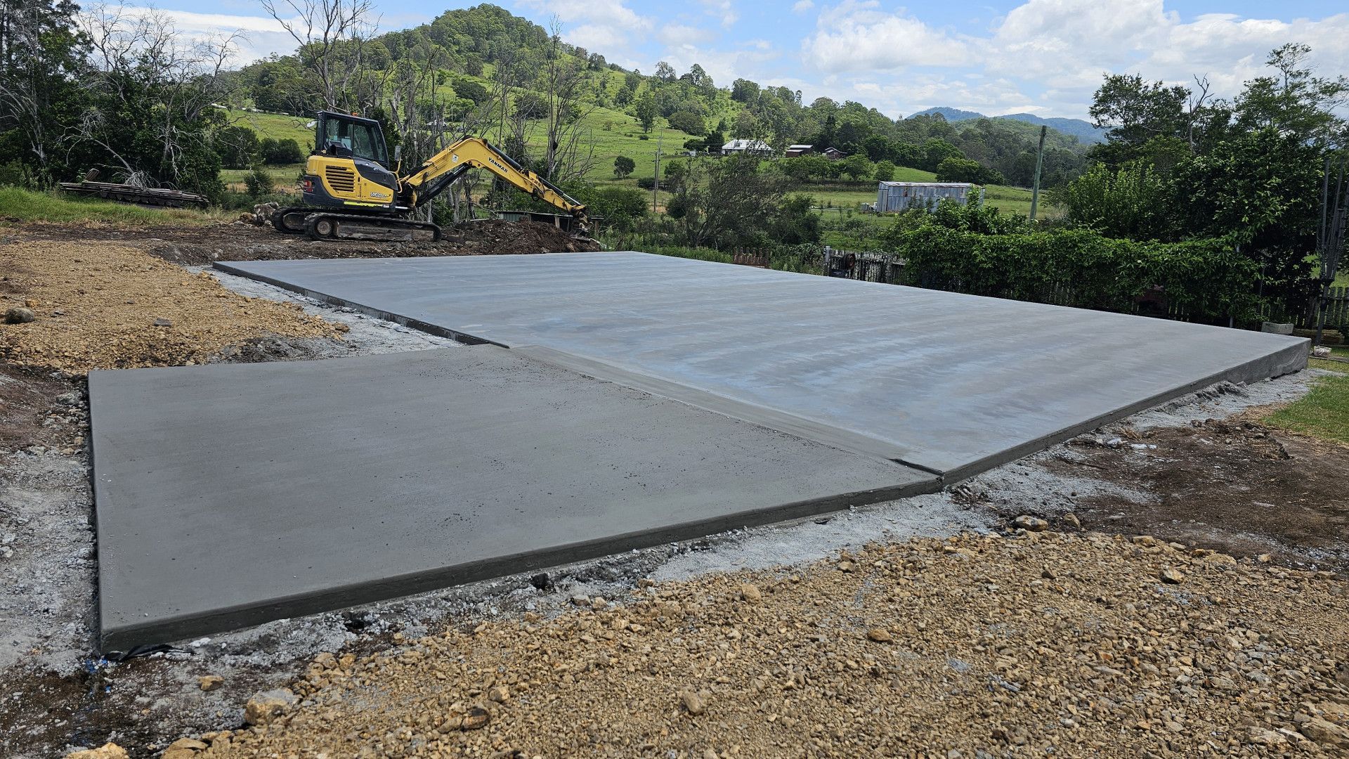 A large concrete slab is being built with a bulldozer in the background. — MidCoast Concreting in Mount George, NSW