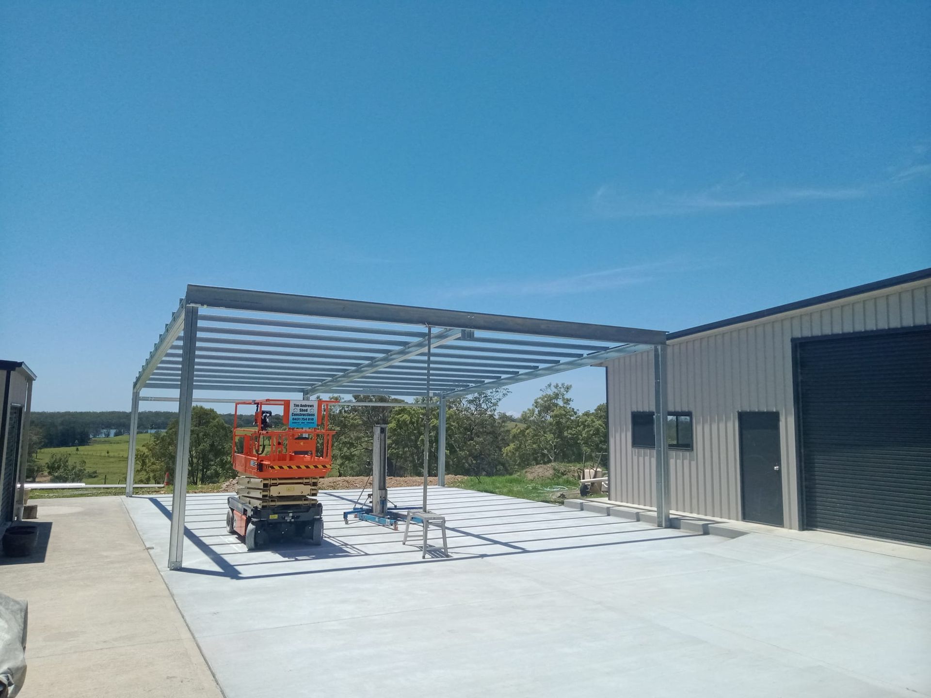 A metal structure is being built in front of a building. — MidCoast Concreting in Forster, NSW