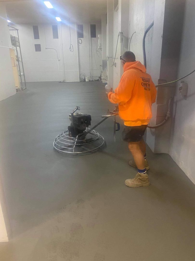 A man is using a machine to finish a concrete floor. — MidCoast Concreting in Tuncurry, NSW