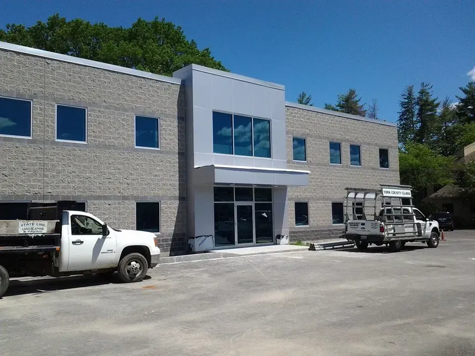 A white truck is parked in front of a large building.