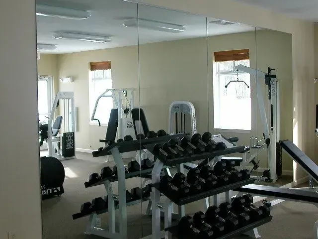 A gym with a lot of mirrors and dumbbells.