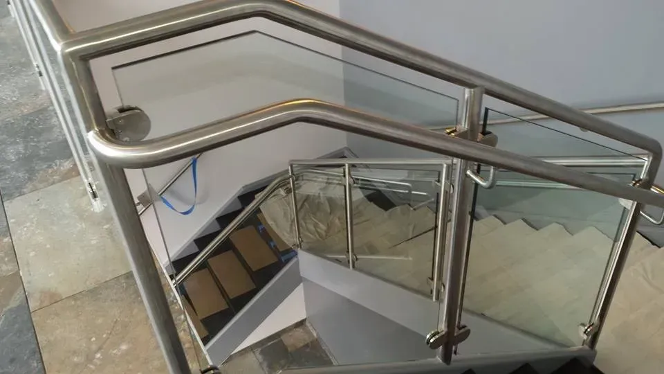 A staircase with a stainless steel railing and glass railing.