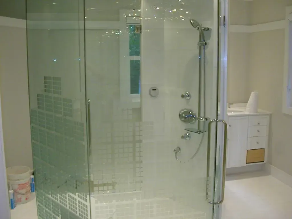 A bathroom with a walk in shower and a sink.