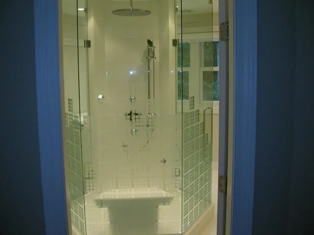 A bathroom with a walk in shower and a tub.