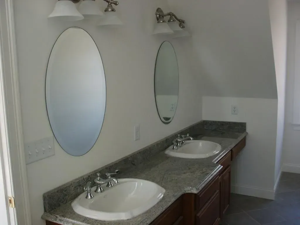 A bathroom with two sinks and two mirrors.