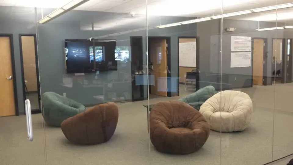 A group of bean bag chairs are sitting in a room with a glass wall.