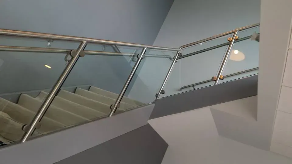 A staircase with a glass railing and a stainless steel railing.