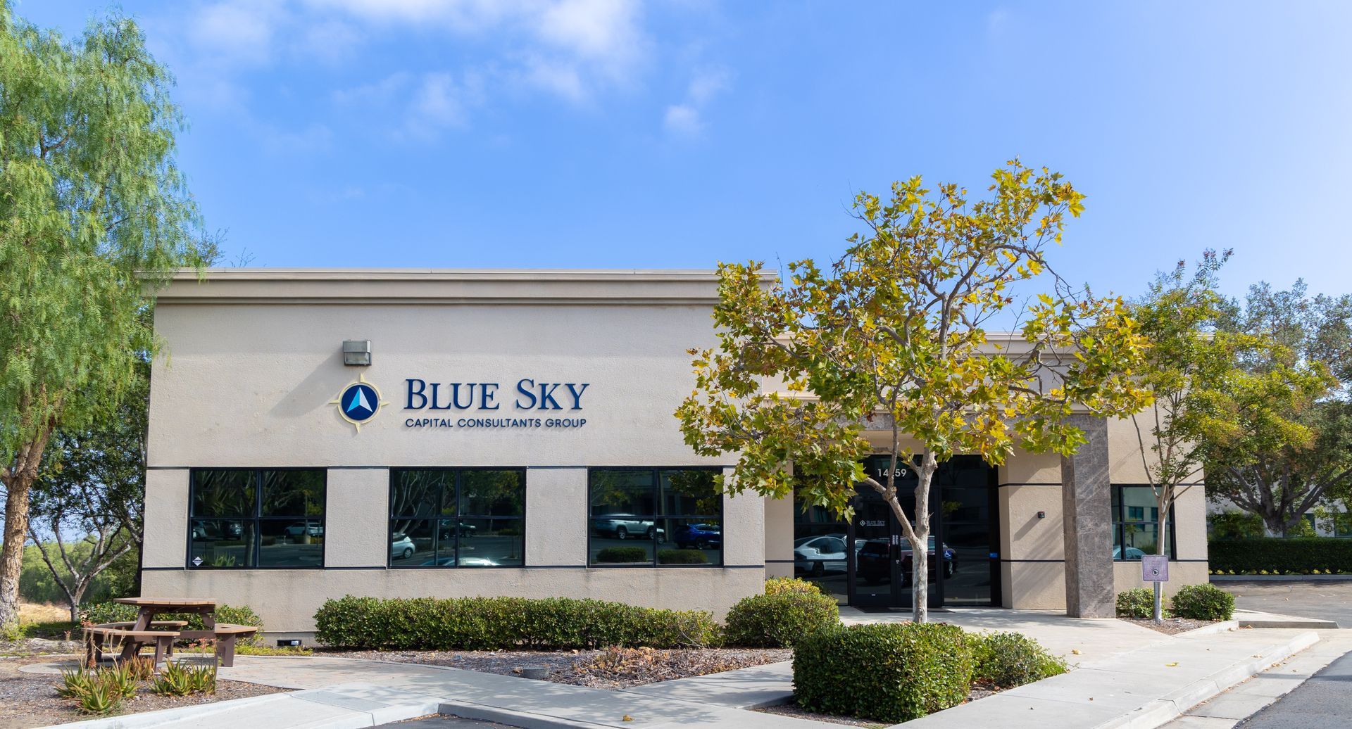 Business meeting: Man presents to colleagues at whiteboard in a sunny office.