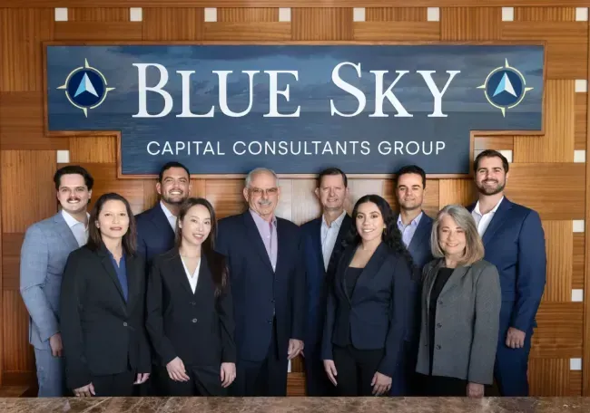 Blue Sky Capital Consultants Group team portrait in front of company sign.