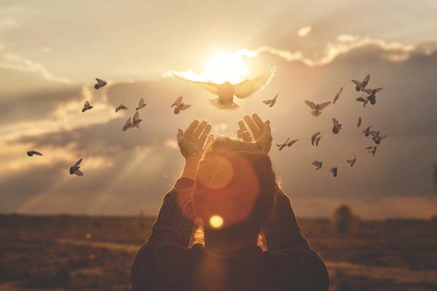 A black can is sitting on a table next to a vase of flowers.