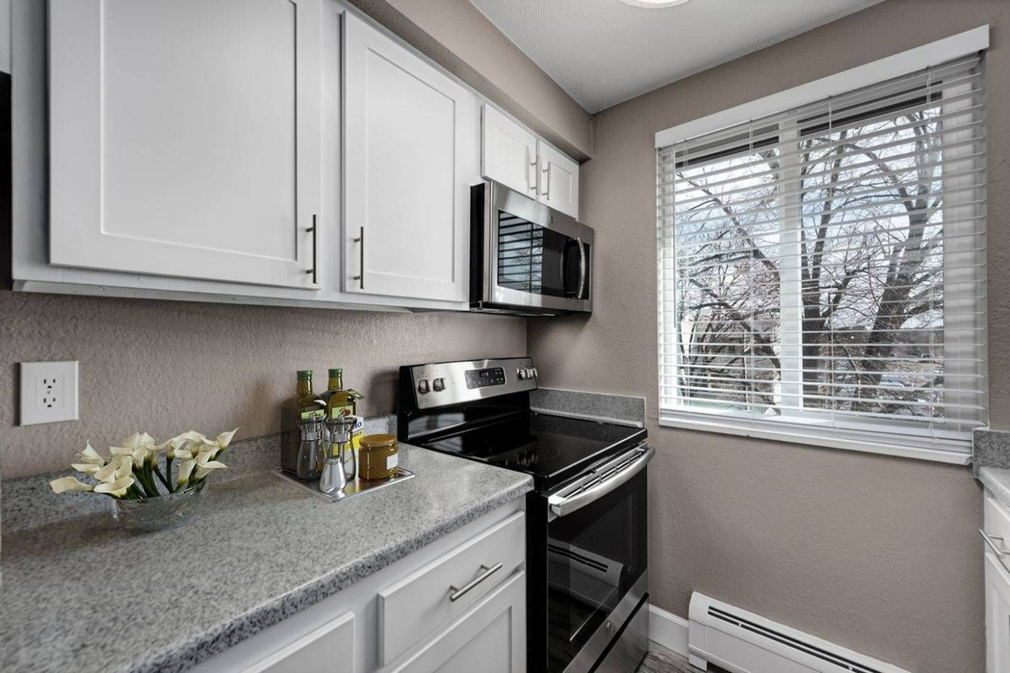 Southglenn Place's modern ktichen with appliances and a window, 