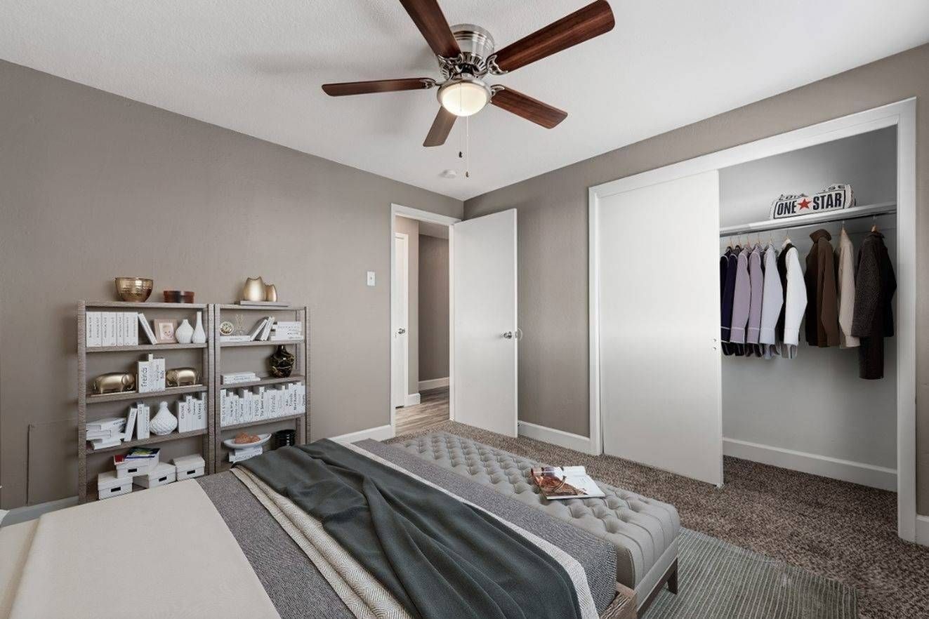 Southglenn Place spacious bedroom with carpet flooring, walk-in closet and ceiling fan. 
