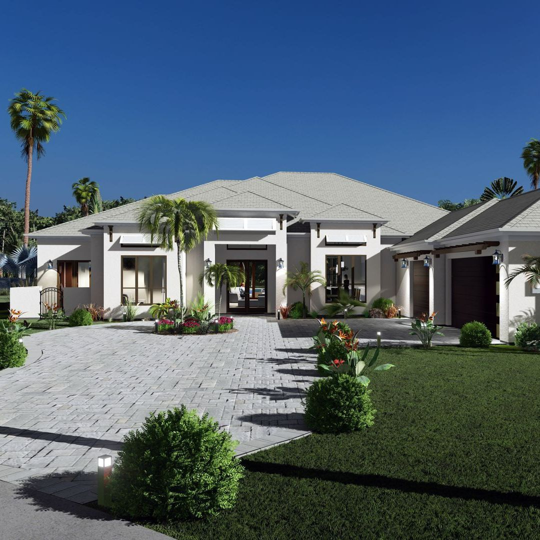 Modern white house with a stone driveway, green lawn, palm trees, and clear blue sky.