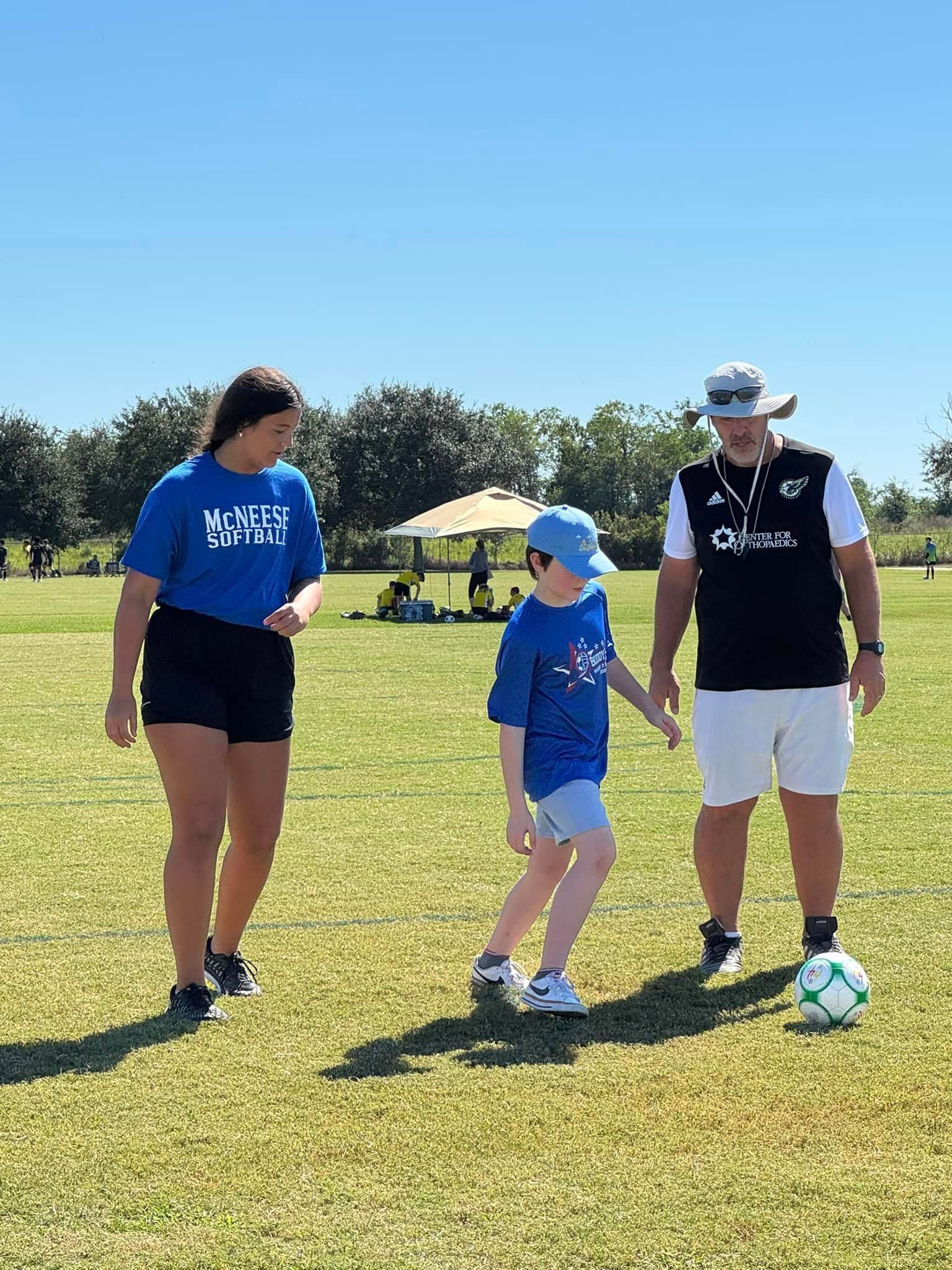 A group of people are playing soccer on a field.