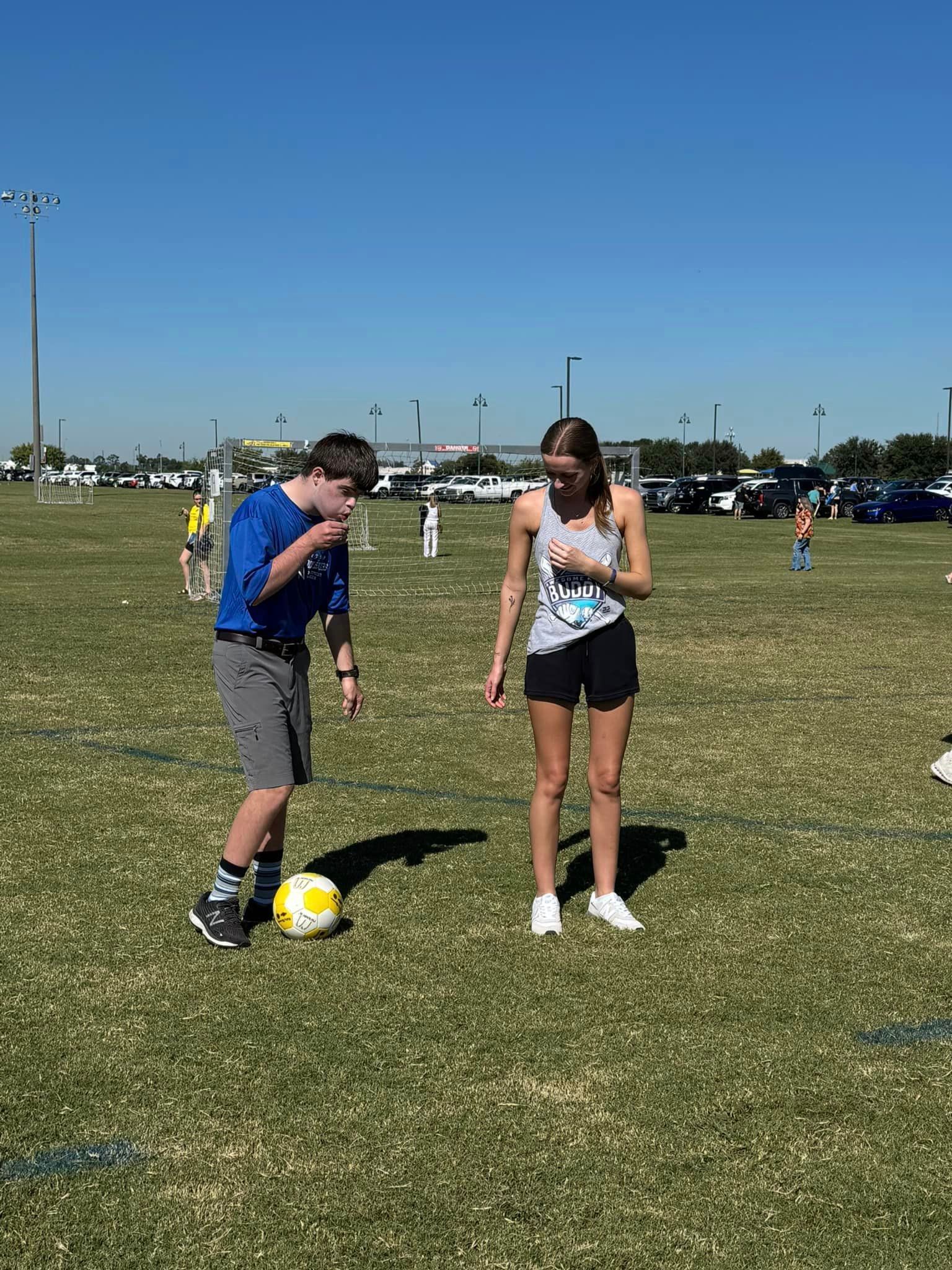 A boy and a girl are playing soccer on a field